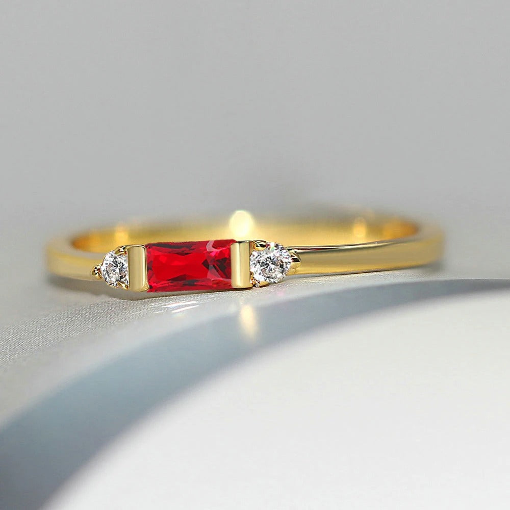 Anillo con piedra central roja dorada y brillante